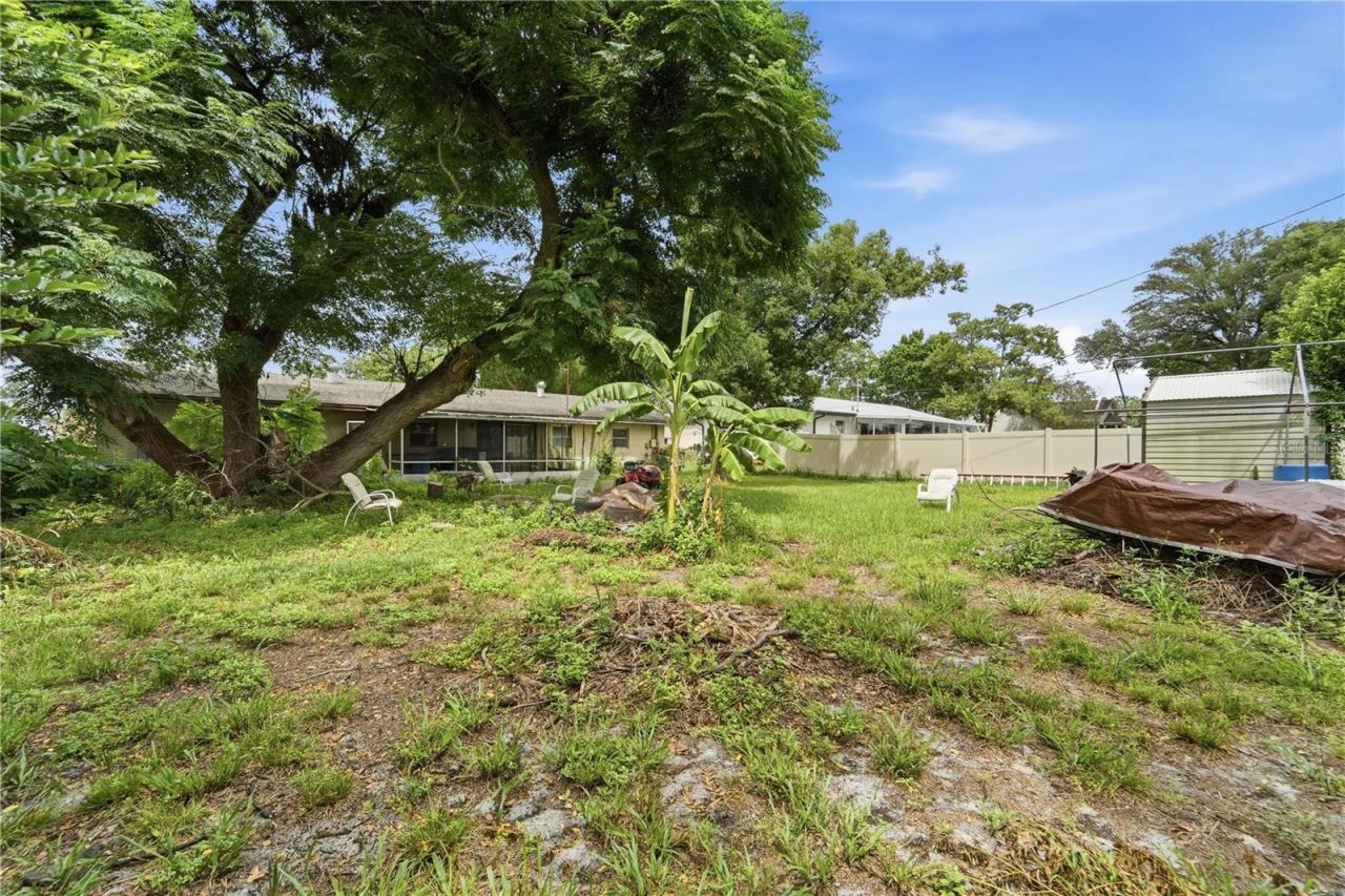 Photo 15 of 16: Mature trees and outdoor space provide plenty of potential in the backyard.