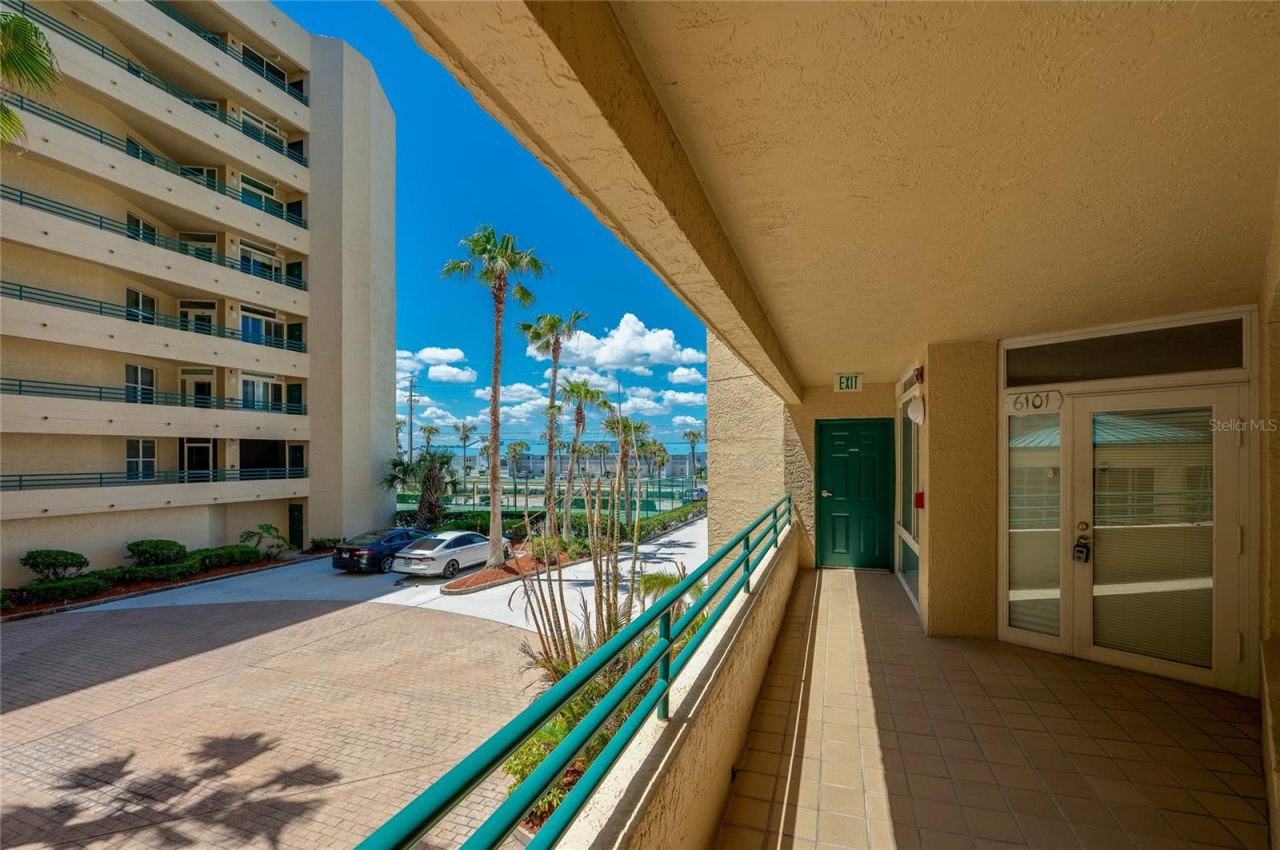 Photo 6 of 20: Covered exterior walkway provides convenient access to the unit, with views of the surrounding grounds and nearby amenities.