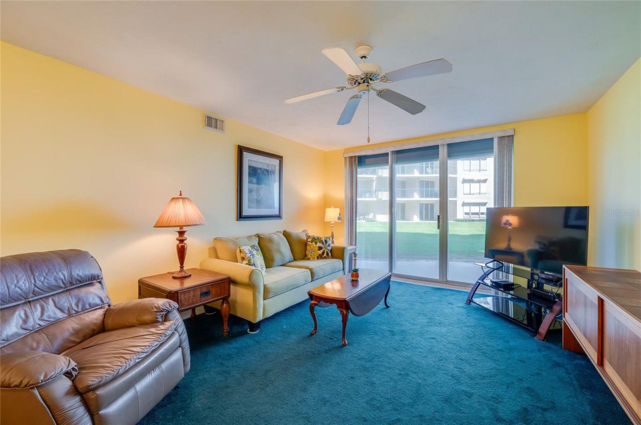 Photo 20 of 20: This comfortable living area features a ceiling fan, and large sliding glass doors that bring in natural light and offer direct access to outdoor views.