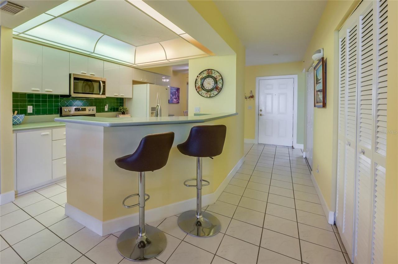 Photo 16 of 20: A convenient breakfast bar with seating provides the perfect spot for casual meals or entertaining guests, while maintaining an open flow to the kitchen.