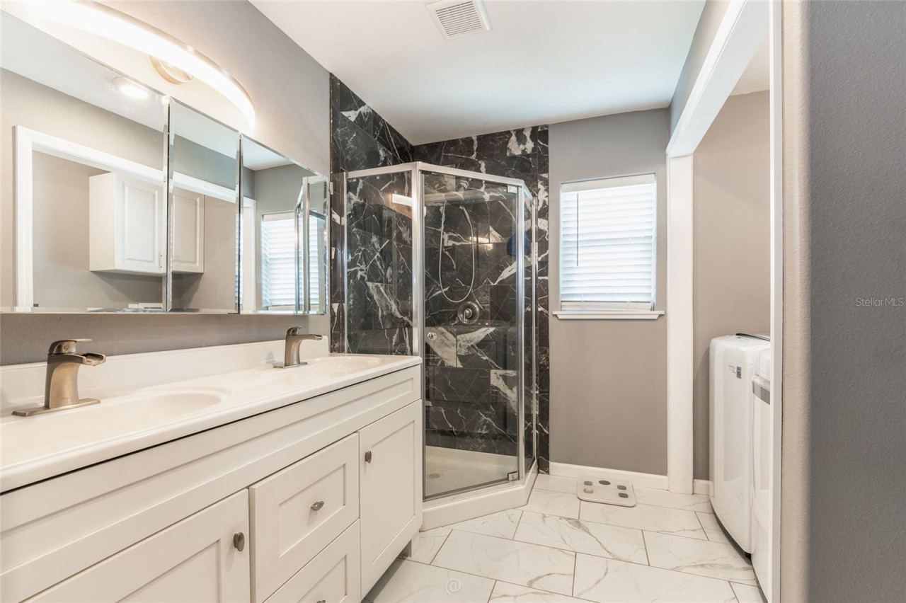Photo 14 of 20: Primary bathroom with dual sinks & walk-in shower. Window to let in natural light