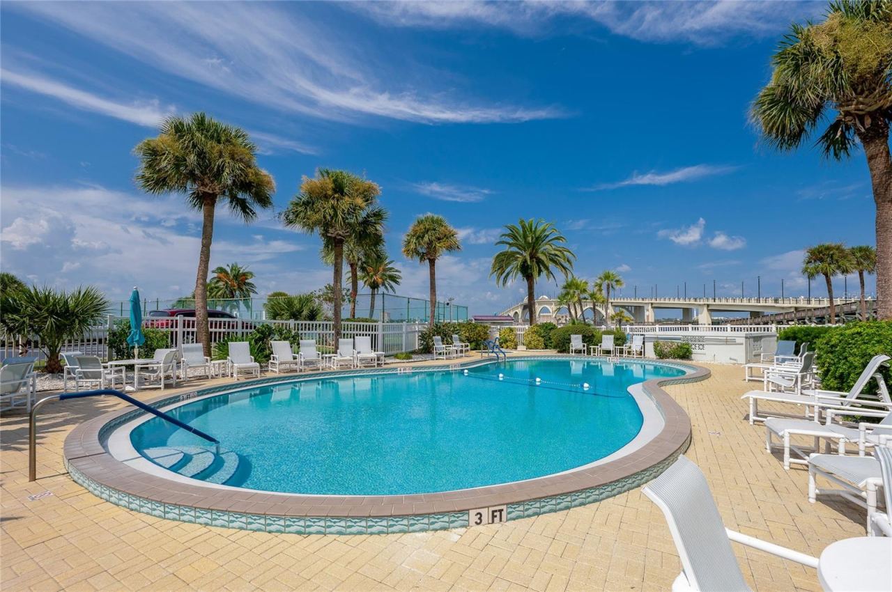 Photo 4 of 20: Spacious pool area with ample seating and tropical landscaping, creating a welcoming environment for residents and guests.