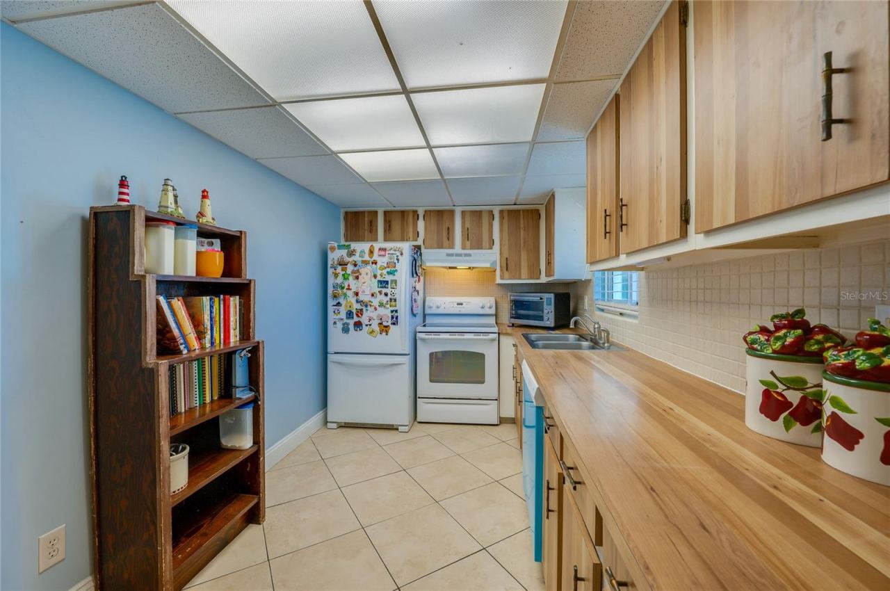 Photo 10 of 20: Functional kitchen with wood cabinetry, ample counter space, and a practical layout ideal for everyday meal prep.