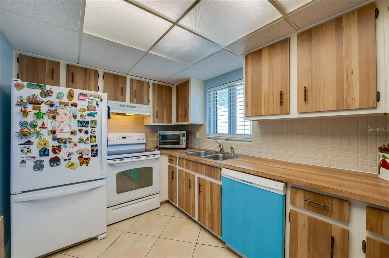 Photo 11 of 20: Bright workspace featuring generous storage, double sink, and efficient appliance placement for easy use.