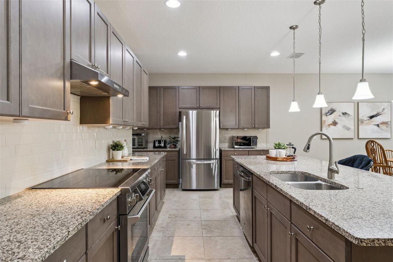 Photo 5 of 20: Kitchen w/ a convection glass top electric range, tile backsplash & stainless steel appliances