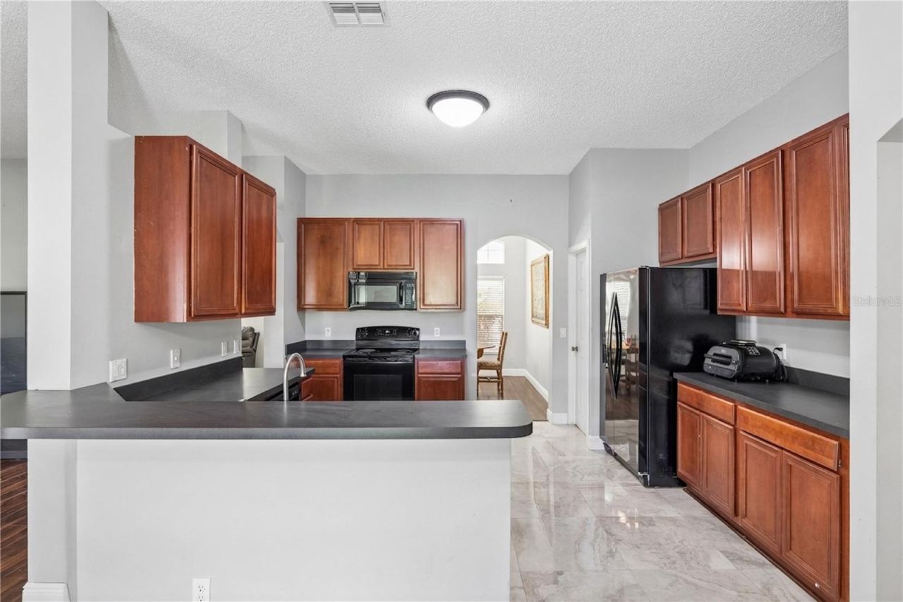 Photo 17 of 20: Highly functional kitchen featuring ample counter space, rich cabinetry, and a breakfast bar