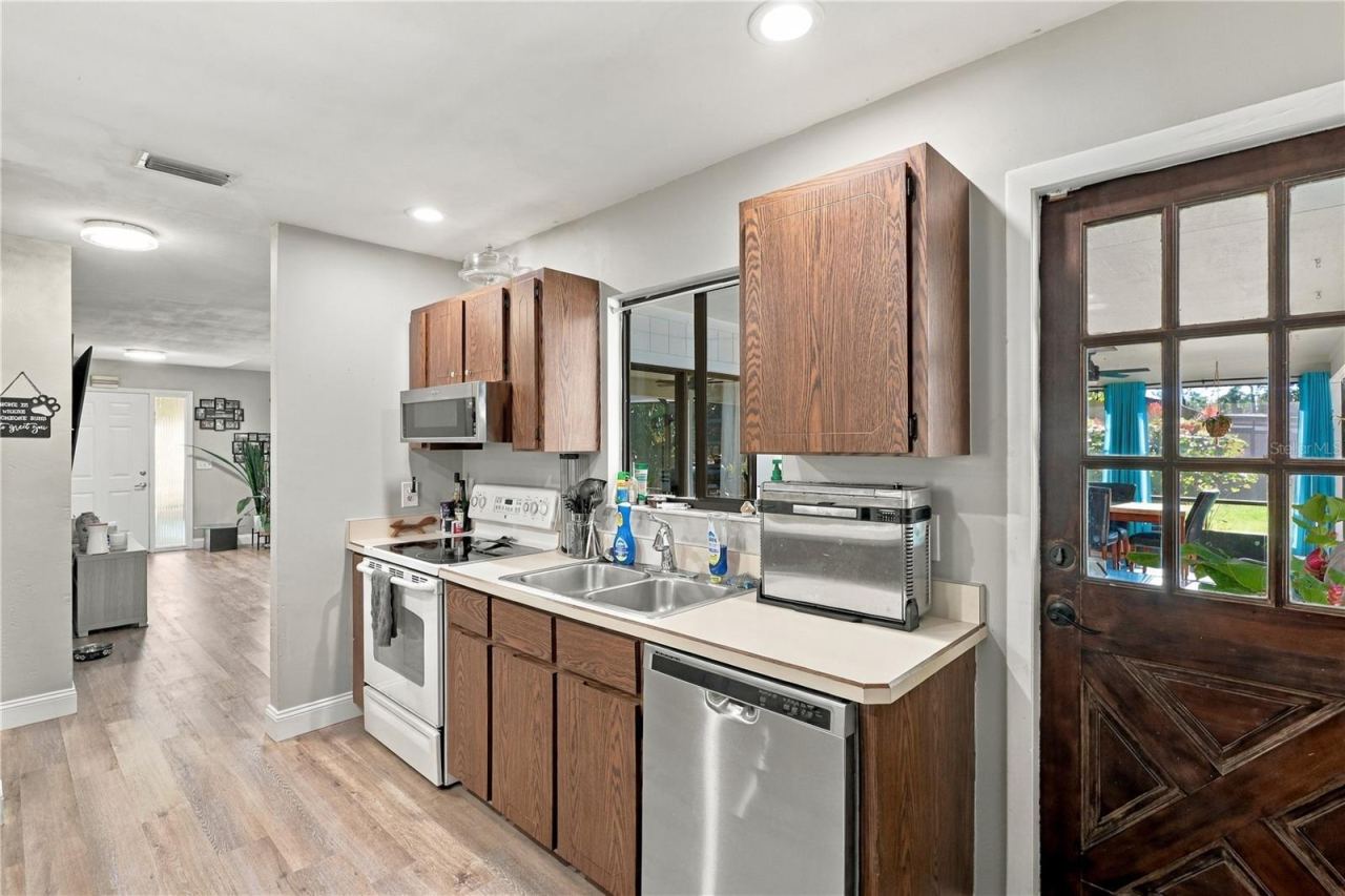 Photo 12 of 20: Kitchen View Toward Front Door, Window Overlooks Back Lanai, Door leads to Covered Lanai, Pool & Spa!