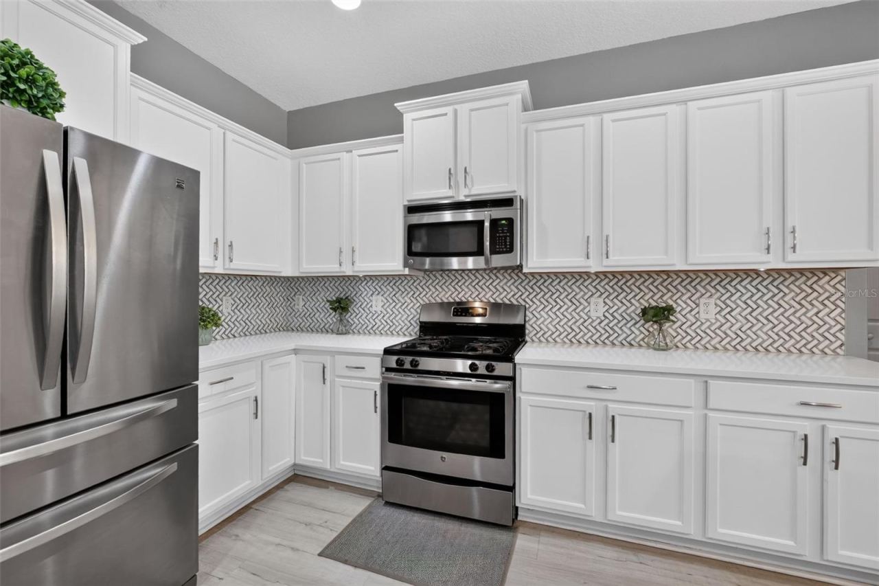 Photo 2 of 20: Stunning kitchen featuring tons of cabinetry, custom tile backsplash and stainless steel appliances!!