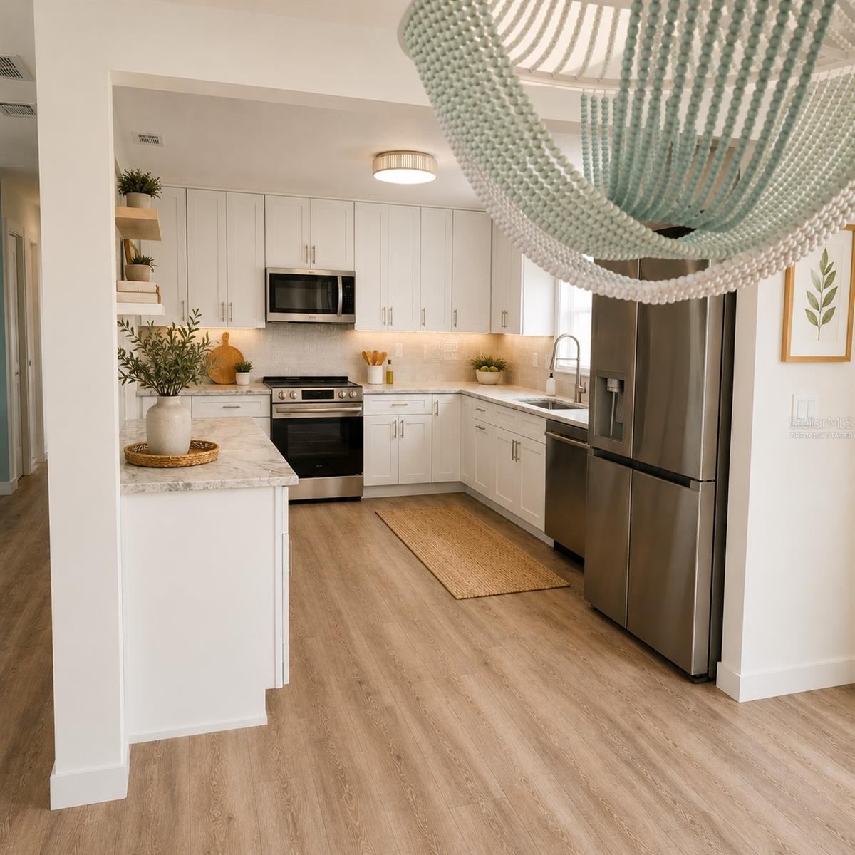 Photo 11 of 20: Virtually Staged. Kitchen View from dining room with shaker cabinets, quartz countertops, designer backsplash, & LG Appliances plus the view!
