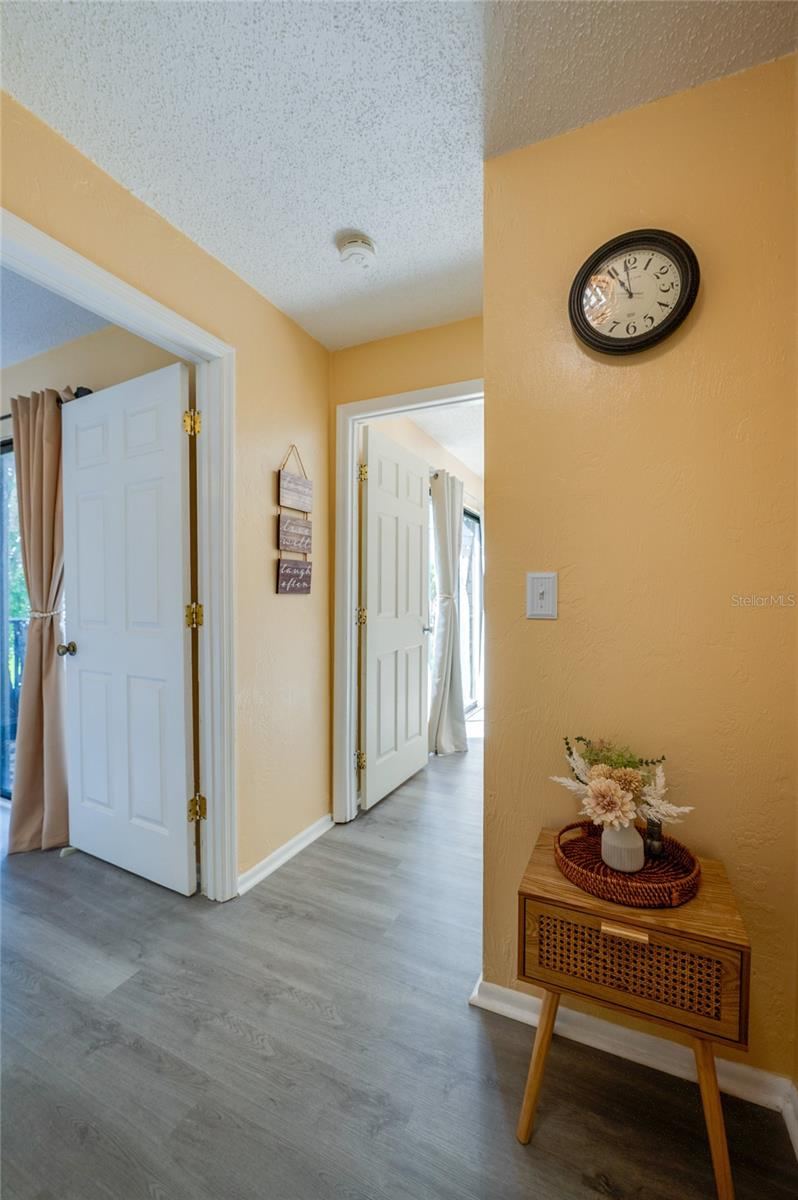 Photo 16 of 20: Bright, welcoming hallway featuring light wood-look flooring, warm yellow walls, and smooth transitions to adjacent rooms.