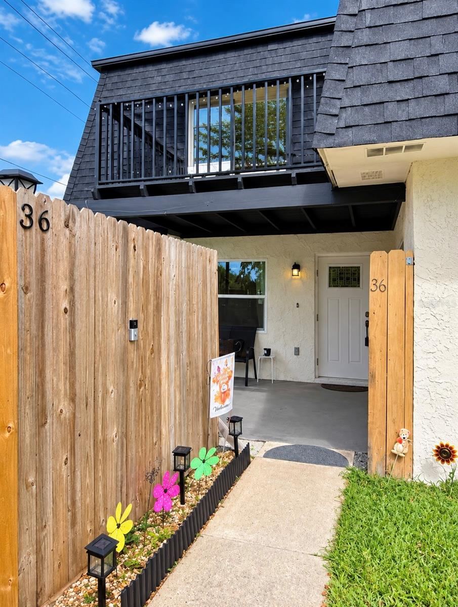 Photo 1 of 20: Exterior entry pathway guided by a wooden privacy fence.