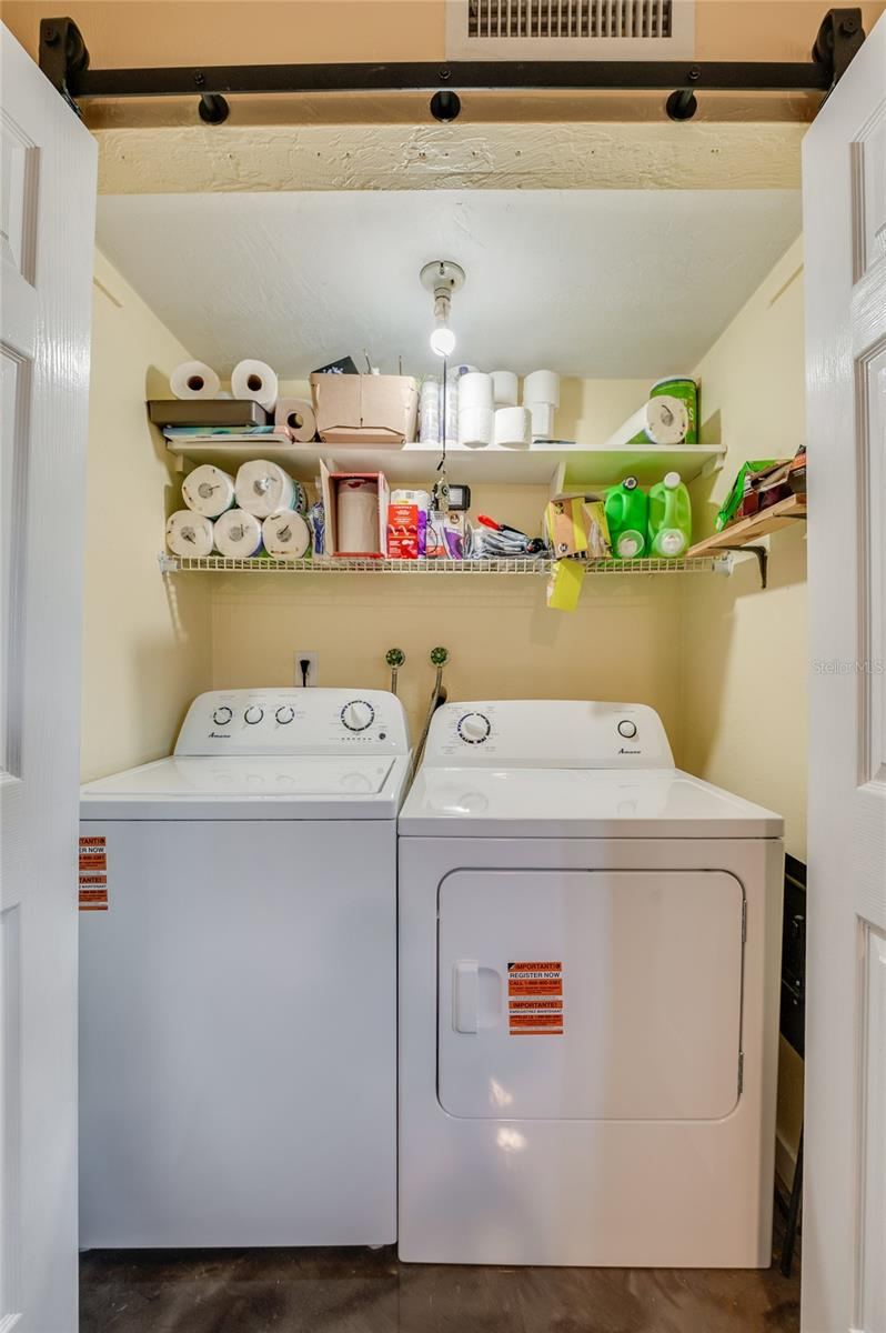 Photo 14 of 20: Convenient laundry nook complete with side-by-side washer and dryer units and overhead wire shelving for extra storage.