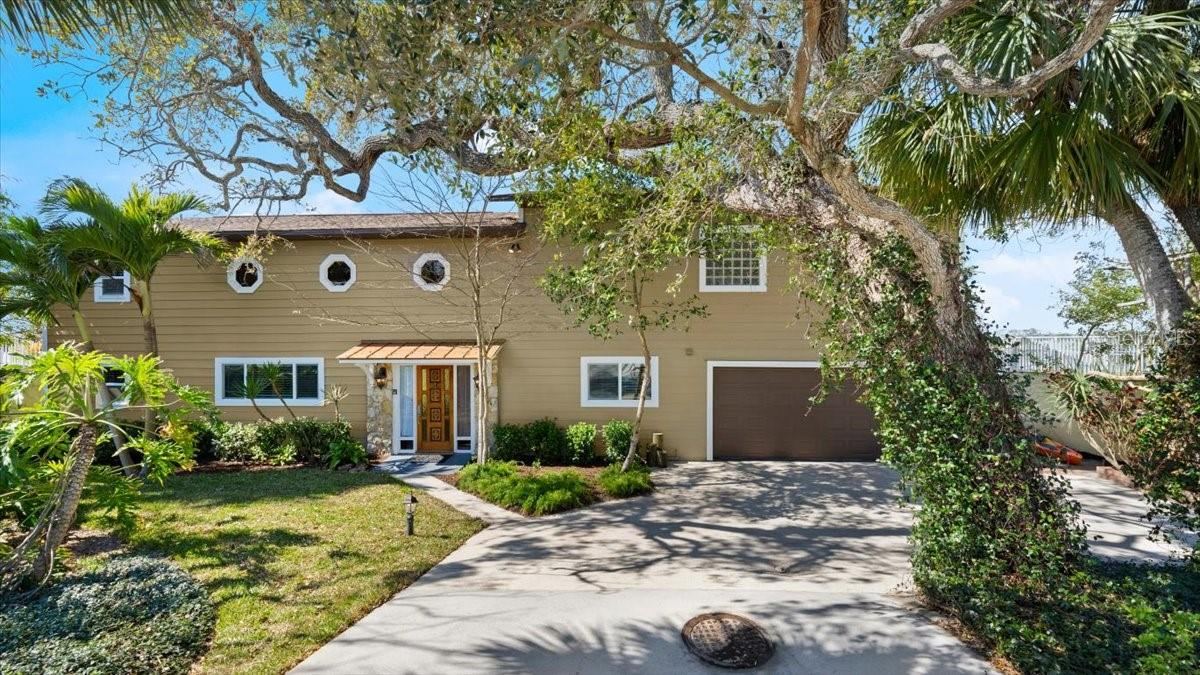 Photo 1 of 20: Exterior front photo of 2306 John Anderson Dr., Ormond Beach, Intracoastal Waterway views, Charming two story home with tropical landscaping, Boat lift and dock, large primary suite