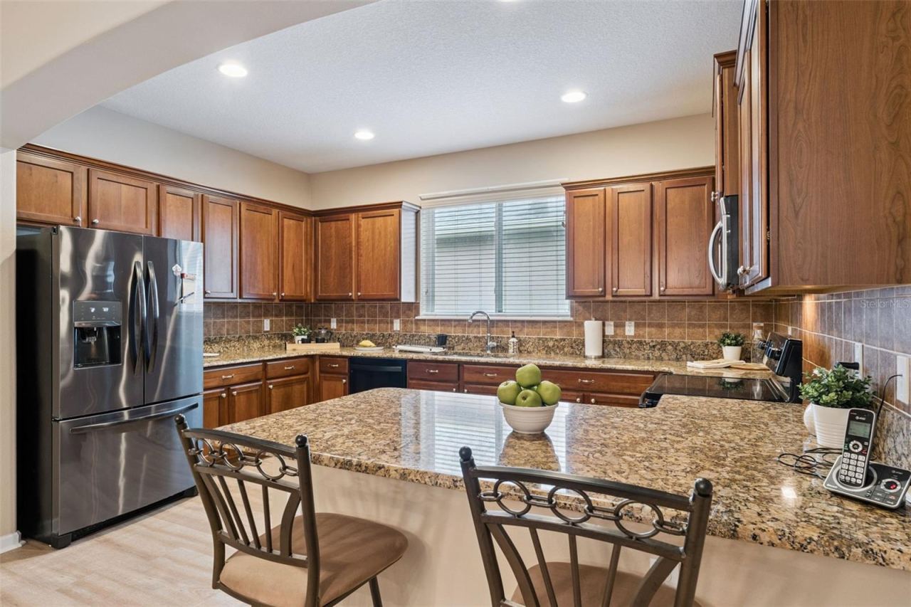 Photo 5 of 20: Kitchen w/ French door style refrigerator, electric glass top range & a breakfast bar