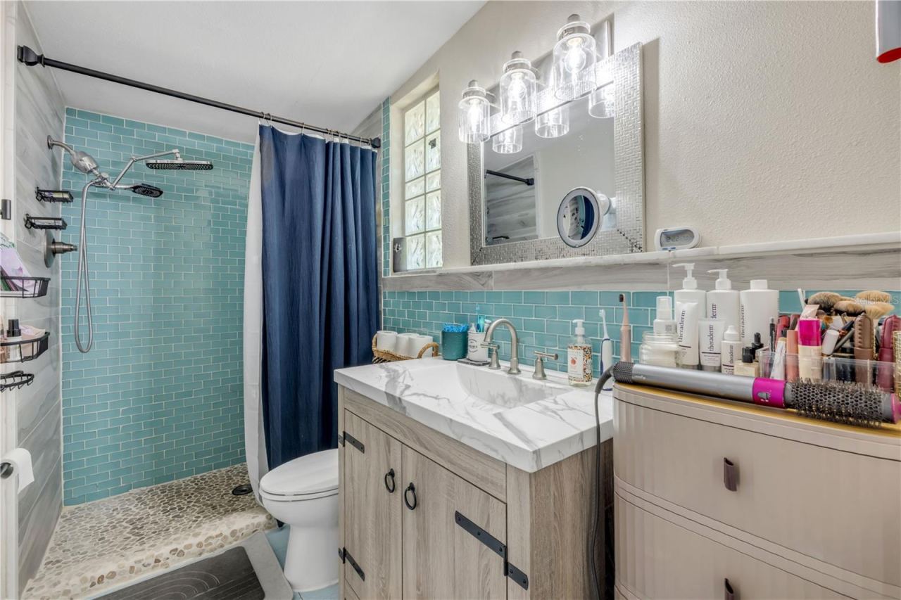 Photo 17 of 20: Bathroom with double-sink vanity and a glass-enclosed shower.