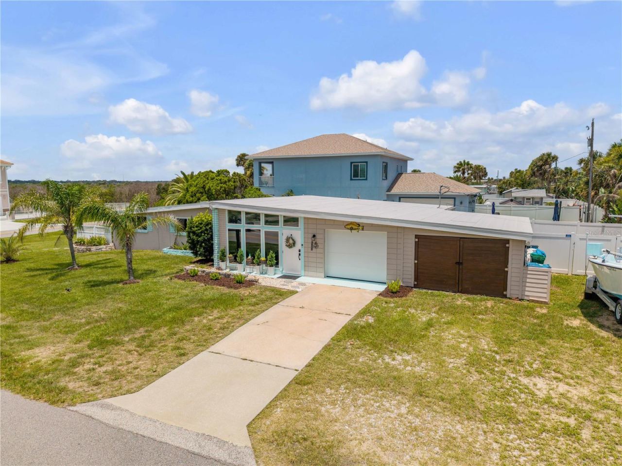 Photo 1 of 20: Front exterior with a broad lawn, driveway and attached garage.