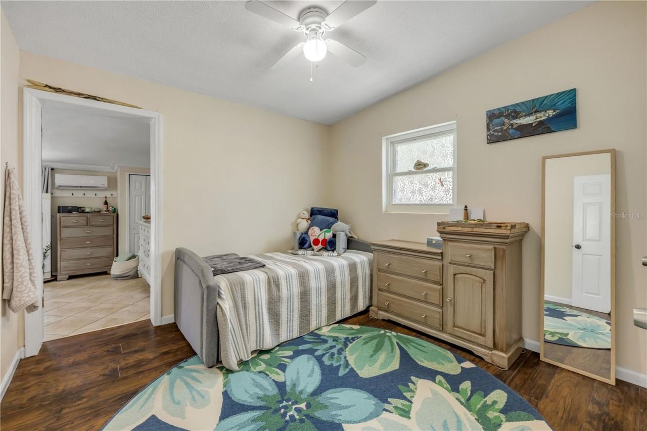 Photo 13 of 20: Bedroom with wood flooring and a ceiling fan.