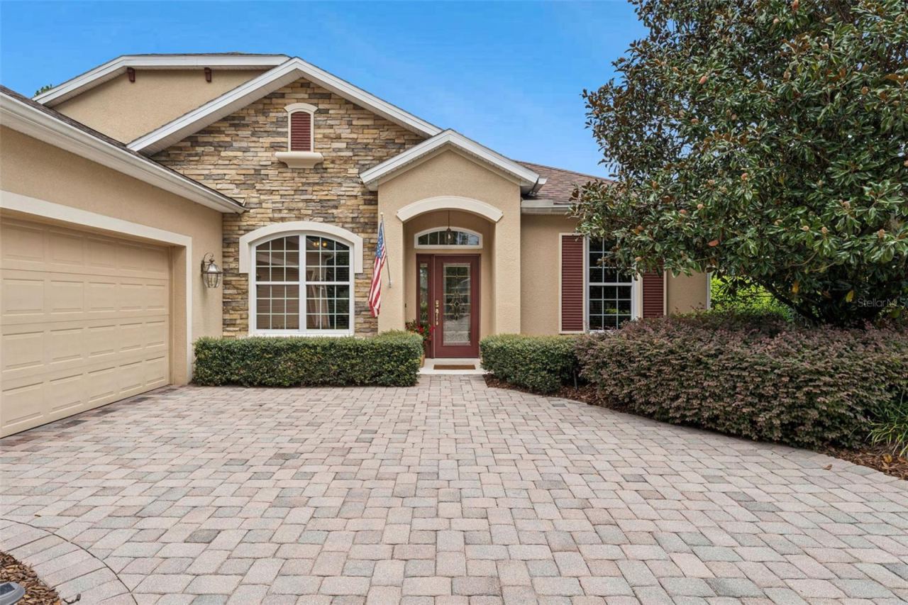 Photo 2 of 20: Exterior front of home w/ a stone facade & a leaded glass front door