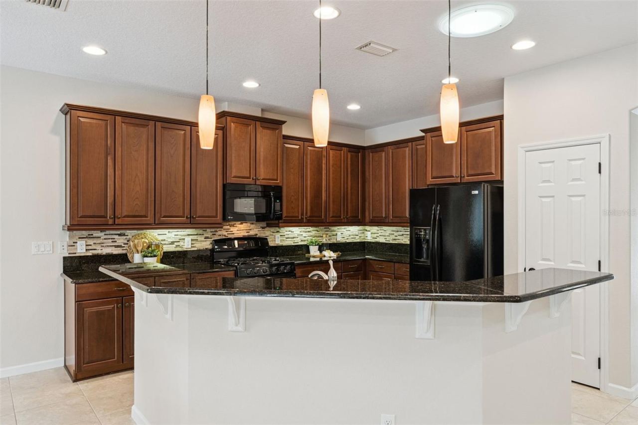 Photo 11 of 20: Kitchen breakfast bar w/ pendant lighting above & a solar tube for additional natural light