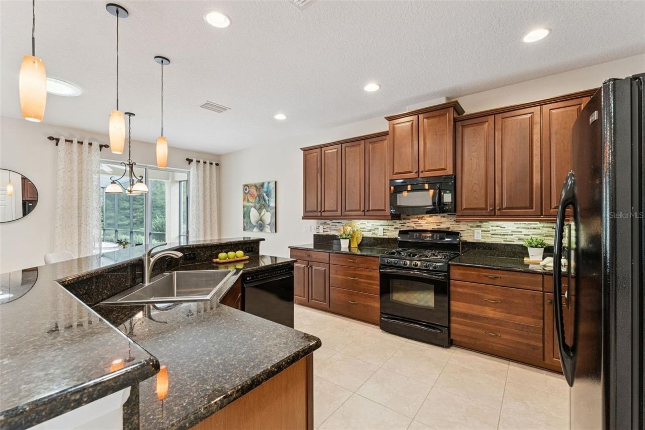 Photo 8 of 20: 12'6" x 14' Kitchen w/ granite countertops, 42" Maple cabinets, under cabinet lighting & a Listello tile backsplash
