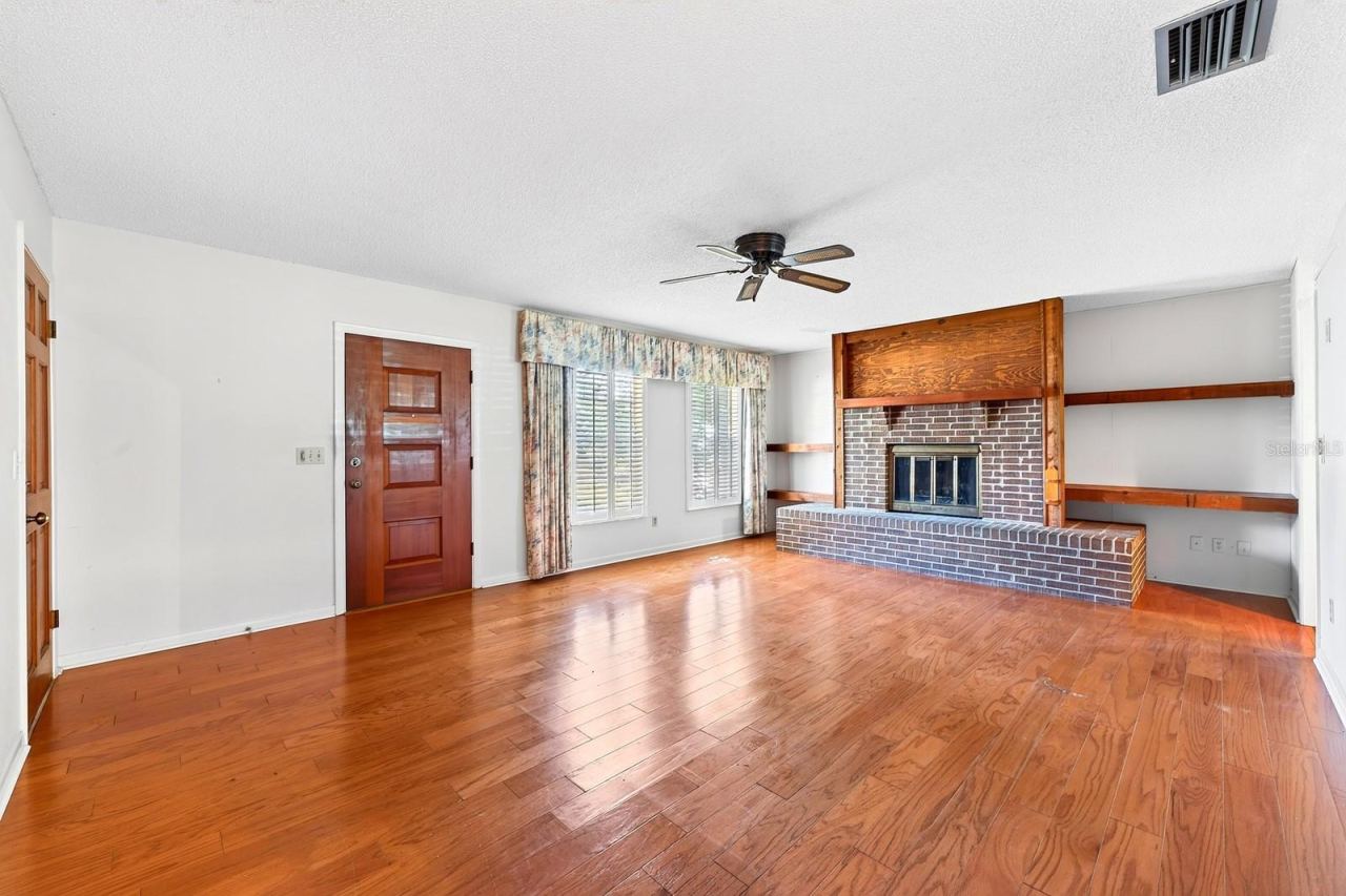 Photo 3 of 20: TILE & WOOD FLOORING extend through the main living areas, beginning with a welcoming living room centered around a WOOD BURNING FIREPLACE.