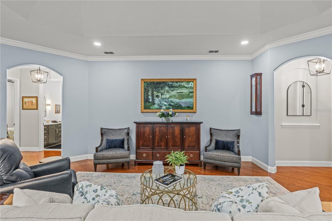 Photo 14 of 20: The "painting" over the cabinet is actually the TV! The arched hallway to the right leads to the primary suite and the arched hallway to the left takes you to the 2 guest rooms and laundry room