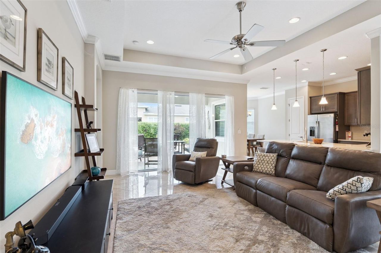 Photo 6 of 20: View of Great Room, Kitchen & stone paver patio w/ privacy hedge