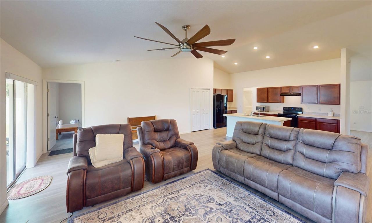 Photo 9 of 20: This open living area feels bright and spacious with vaulted ceilings, recessed lighting, and an easy flow into the kitchen, while the large center island helps anchor the space for casual seating and gathering.