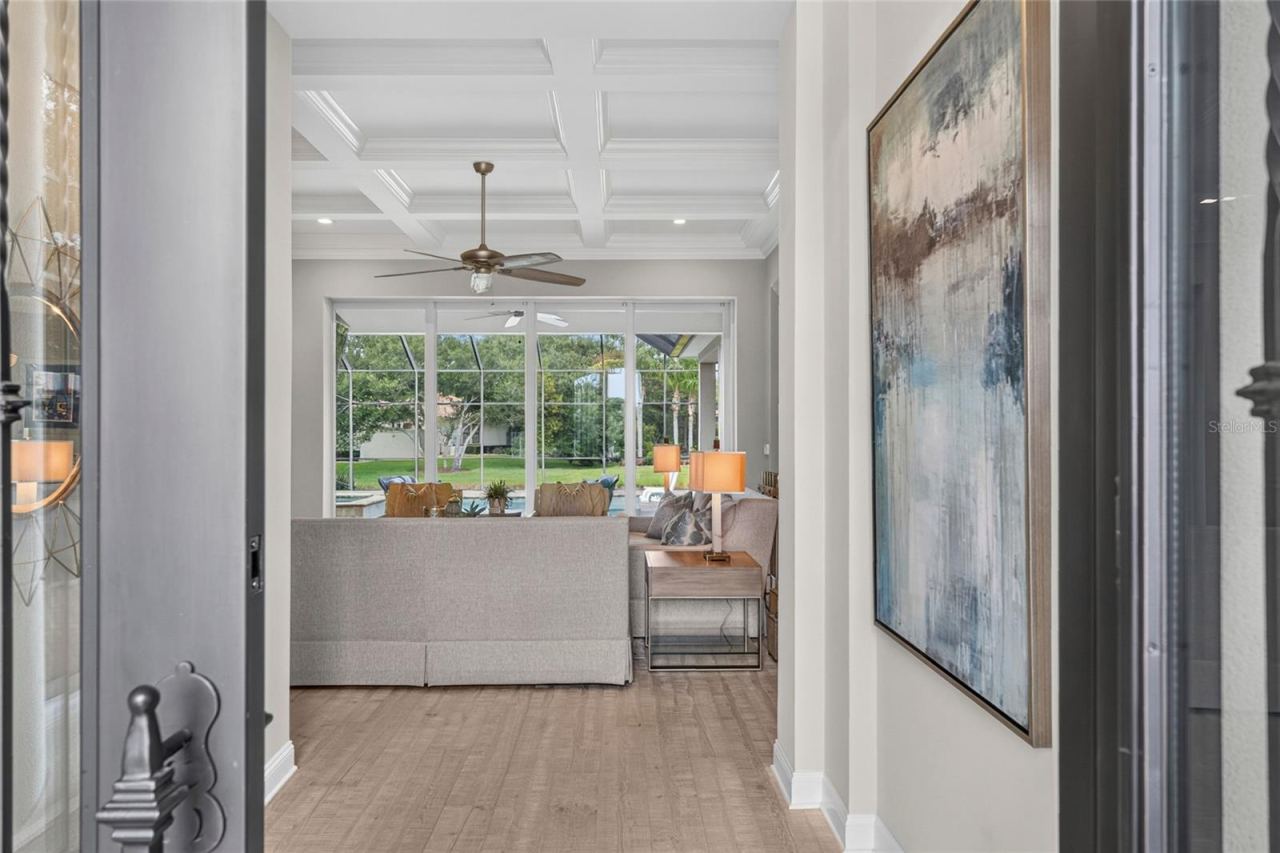 Photo 3 of 20: The moment you step inside, your eye is drawn straight through to the sunlit outdoor setting—a captivating sightline that instantly connects the home’s polished interior with its resort-inspired lifestyle.