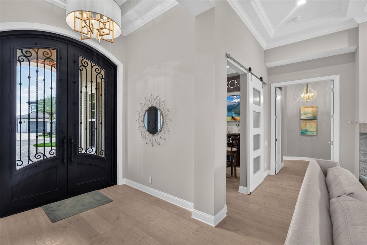 Photo 13 of 20: A grand welcome with a designer’s touch—custom bronze-and-glass doors, dramatic ceiling height, and refined architectural details create an entrance that feels unmistakably special.