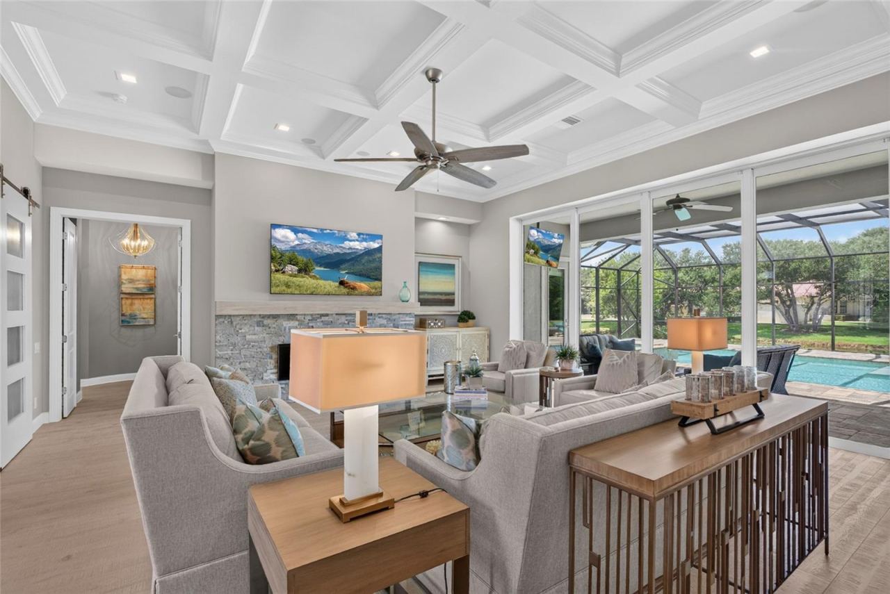 Photo 16 of 20: Disappearing sliding glass doors open the great room completely to the pool and lanai, creating a seamless indoor-outdoor experience made for Florida’s signature way of life.