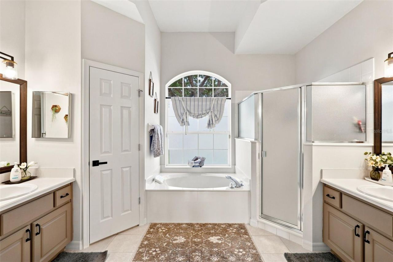 Photo 19 of 20: Dual vanity bathroom with his & hers closet space inside primary bedroom.