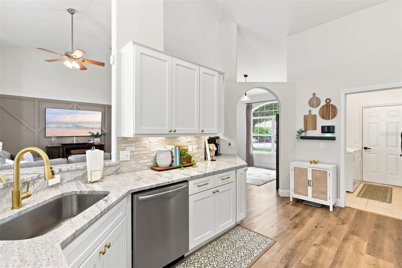Photo 6 of 20: Remodeled kitchen towards indoor laundry room and garage at right. Open to main living area at left.