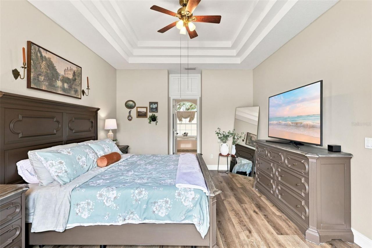Photo 17 of 20: Primary bedroom with gorgeous tray ceiling and ceiling fan.