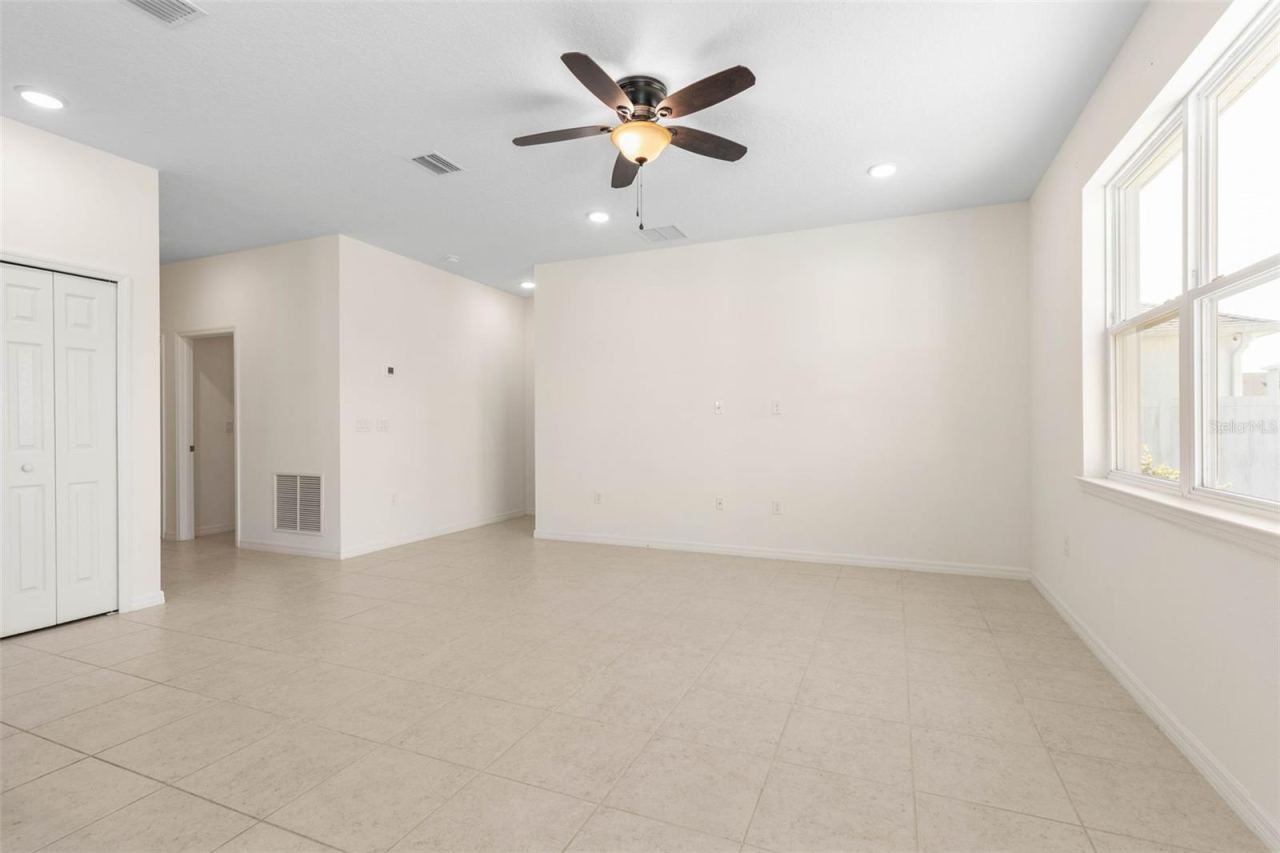 Photo 10 of 20: Bright, open living area with neutral tile flooring, recessed lighting, and a seamless flow into the kitchen—perfect for comfortable everyday living and entertaining.