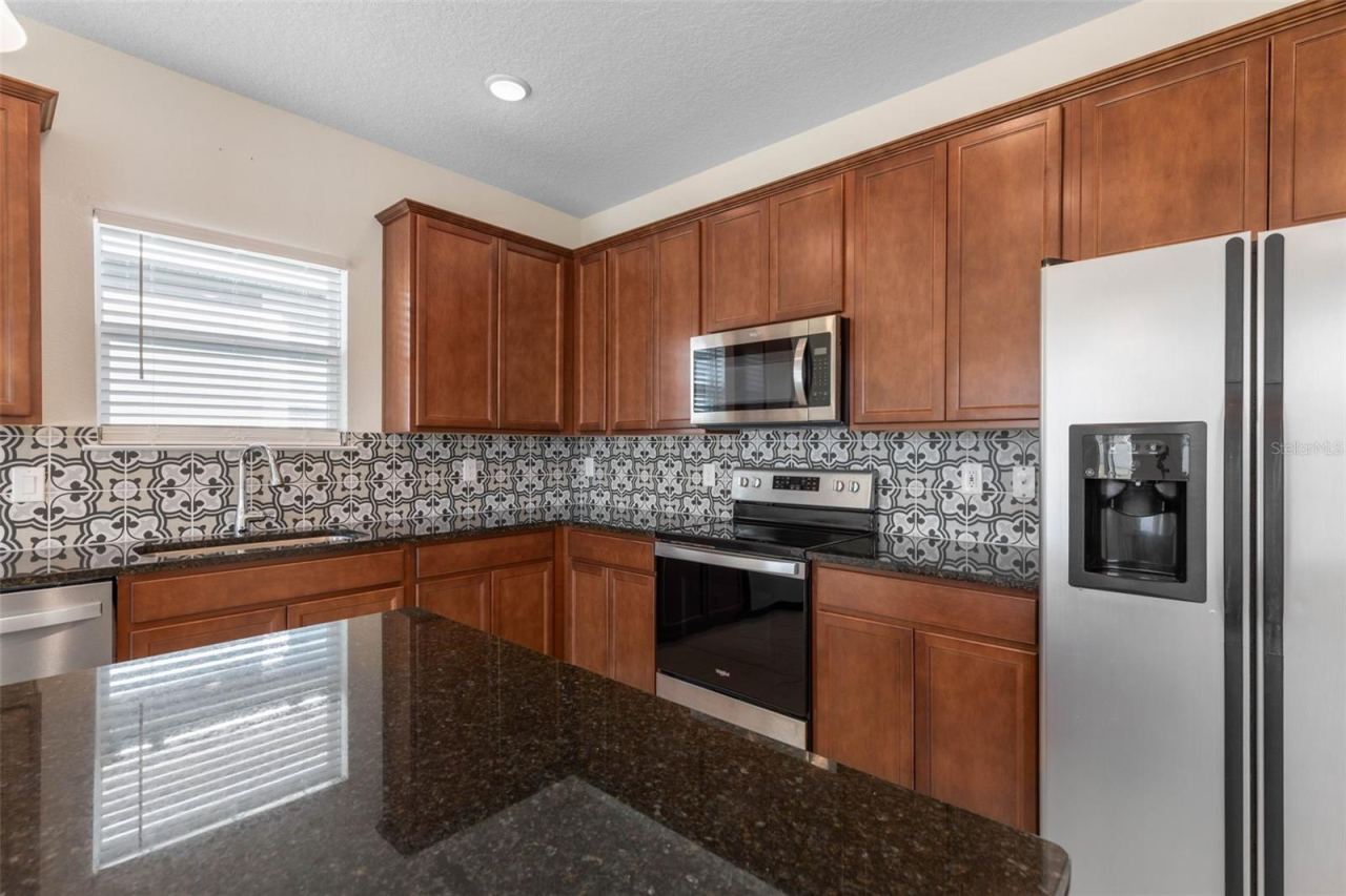 Photo 19 of 20: Eye-catching tile backsplash brings texture and visual interest to the kitchen, perfectly complementing the cabinetry