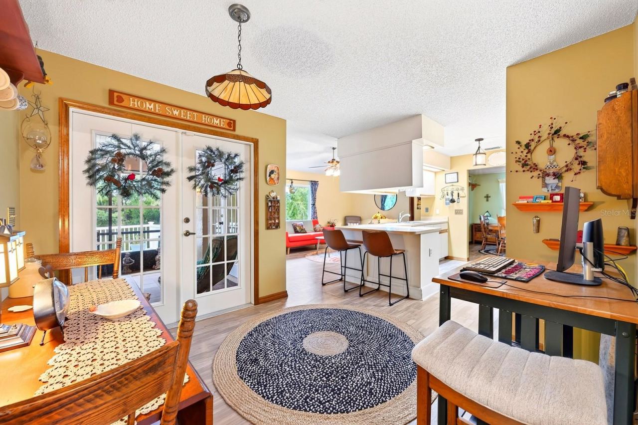 Photo 14 of 20: A spacious Breakfast Nook presents another inviting spot to start the day, with GLASS-PANELED FRENCH DOORS opening to the covered, enclosed FLORIDA ROOM.