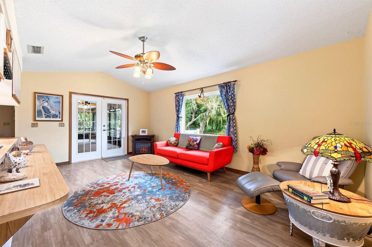 Photo 8 of 20: A set of GLASS-PANELED FRENCH DOORS in the Family Room open directly to the Florida Room, making it easy to move between the indoor living spaces and your own backyard retreat.