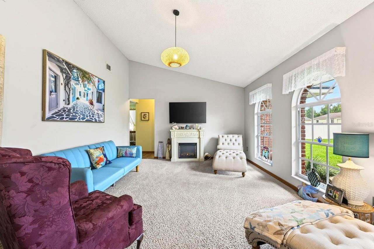 Photo 5 of 20: Step inside to a formal Living Room featuring plush carpeting and three ELEGANT ARCHED WINDOWS that fill the space with natural light.