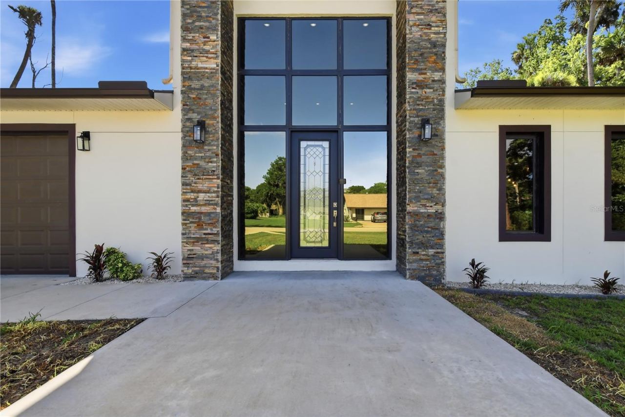 Photo 3 of 20: A soaring front entry with expansive floor-to-ceiling glass welcomes abundant natural light into the home, highlighting the modern architecture while creating an elegant and airy ambiance throughout the main living space.