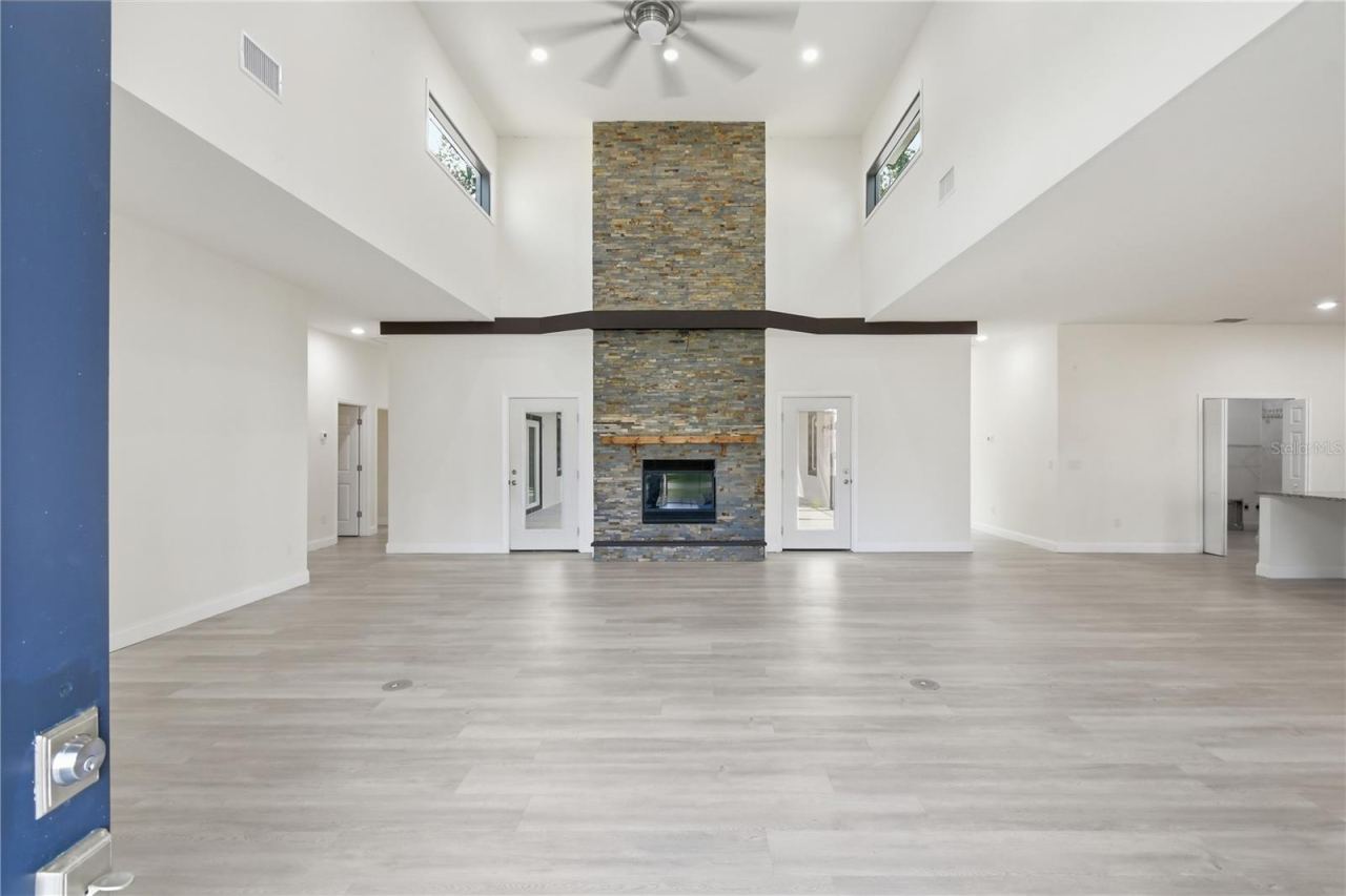 Photo 4 of 20: From the moment you walk through the front door, you're greeted by a dramatic open living space with soaring ceilings, expansive sightlines, and a spectacular floor-to-ceiling double-sided stone fireplace