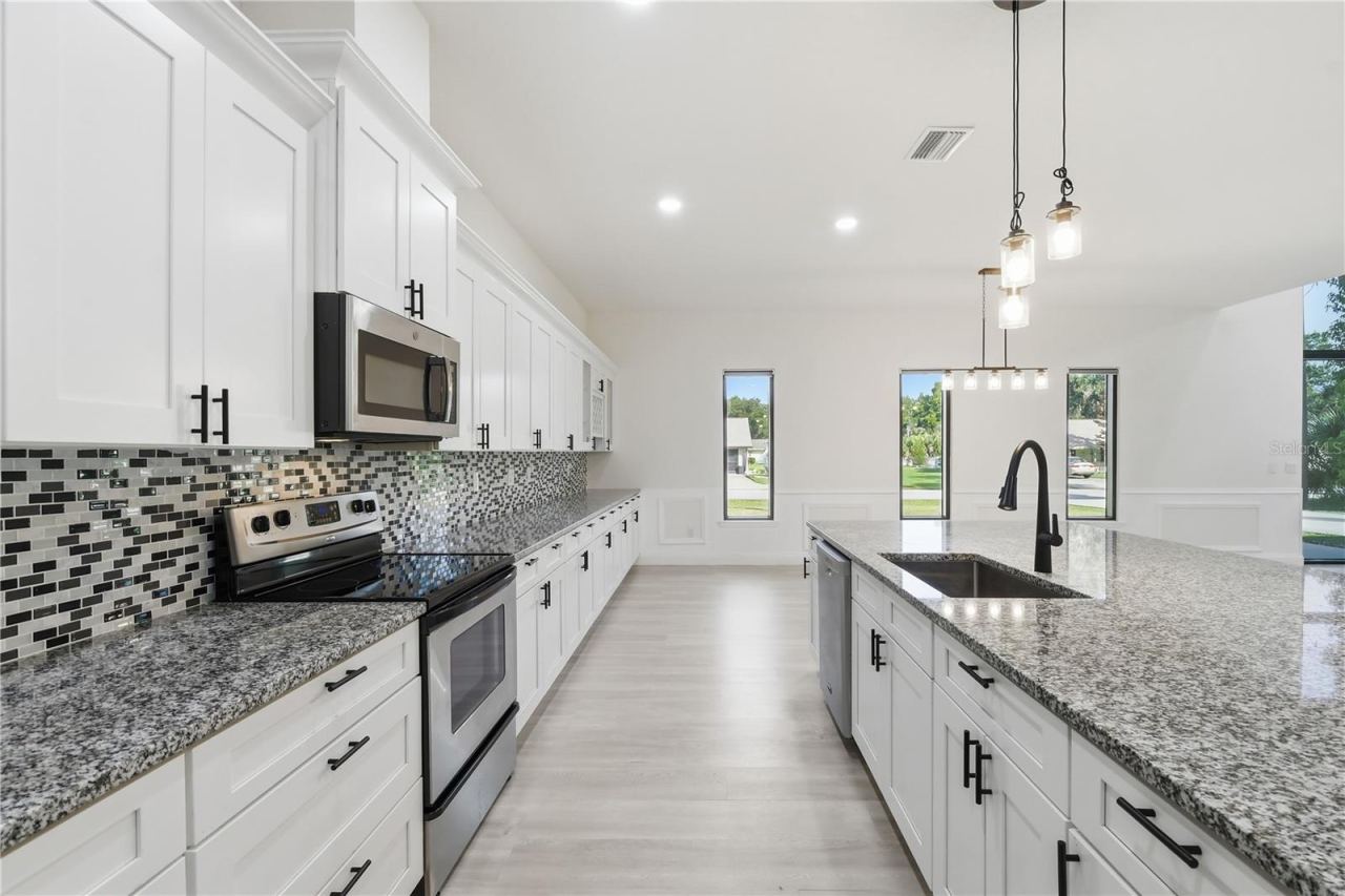 Photo 13 of 20: This beautifully appointed kitchen offers an abundance of soft-close cabinetry and drawers, providing generous storage without sacrificing style. The oversized granite island and extensive counter space create the perfect setting for preparing meals…