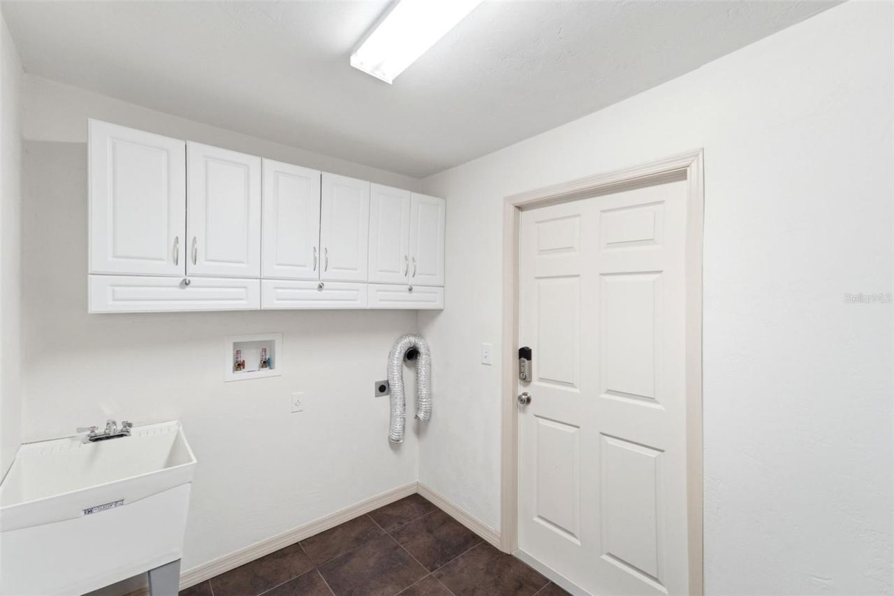 Photo 19 of 20: Functional laundry room with additional cabinetry for extra storage.