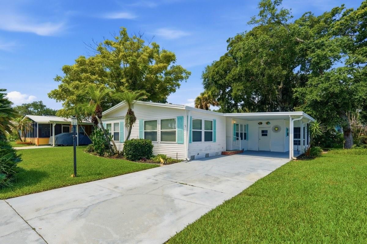 Photo 2 of 20: Front of Home showing Carport, Storage. Notice the long driveway