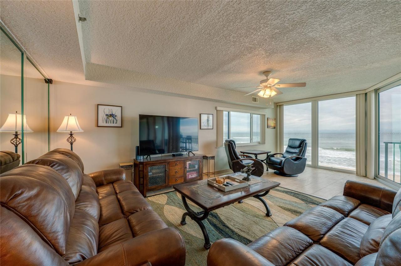 Photo 8 of 20: The living area features full-length windows with unobstructed ocean views and access to the balcony an ideal setting for relaxing or hosting guests.