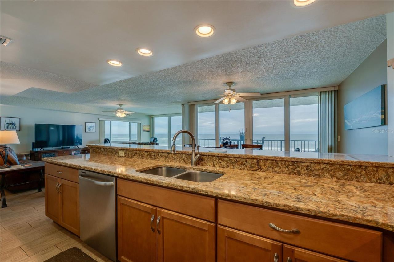 Photo 19 of 20: Enjoy breathtaking ocean views directly from the kitchen sink, with an open sightline through the dining and living areas to the balcony beyond.
