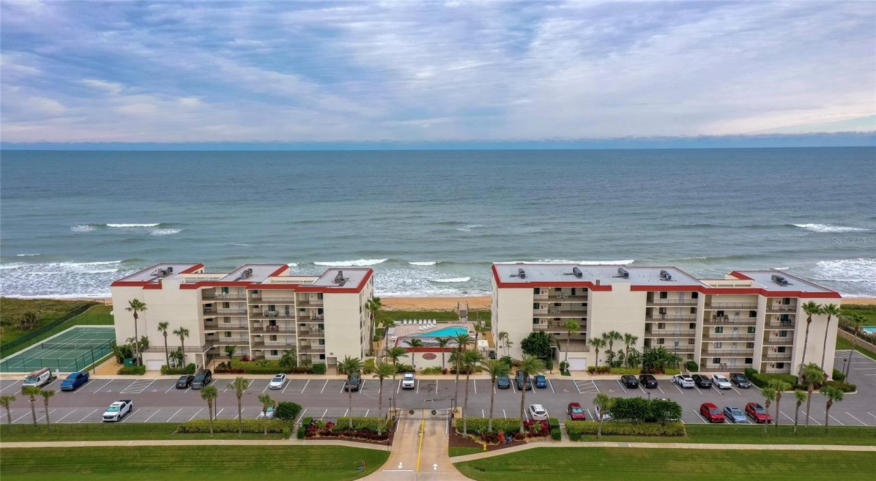 Photo 1 of 20: This beautifully maintained oceanfront community features two mid-rise buildings, a central pool area, and tennis courts—all nestled along the coast with panoramic Atlantic views.