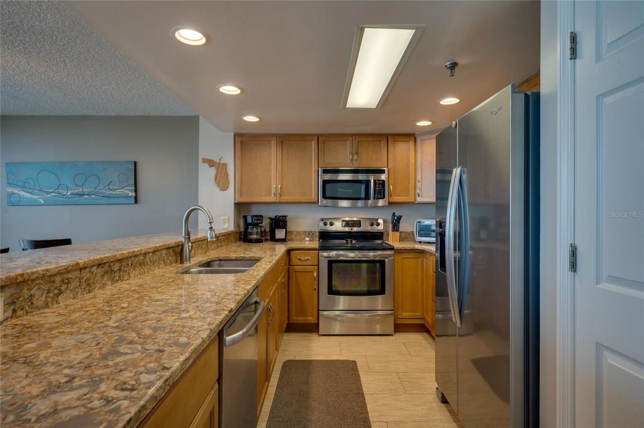 Photo 17 of 20: The L-shaped layout maximizes counter space and efficiency and recessed ceiling lights for a bright and modern feel.