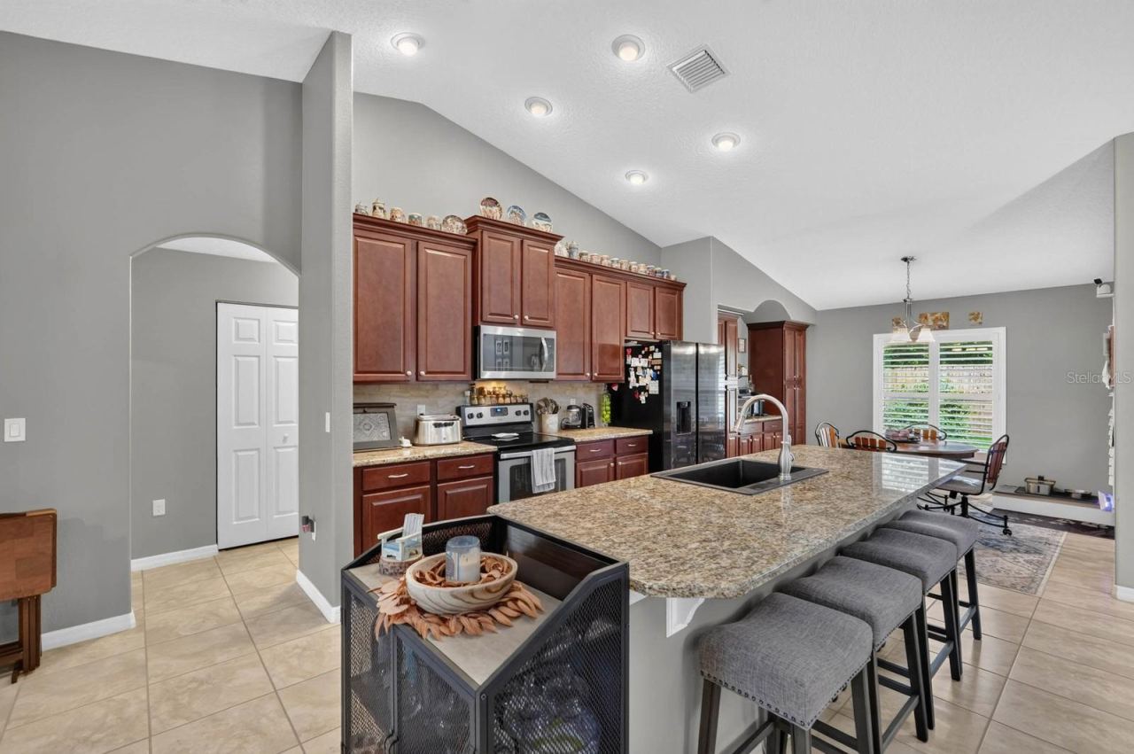 Photo 5 of 20: Kitchen features stacked wood cabinetry, granite countertops, large island