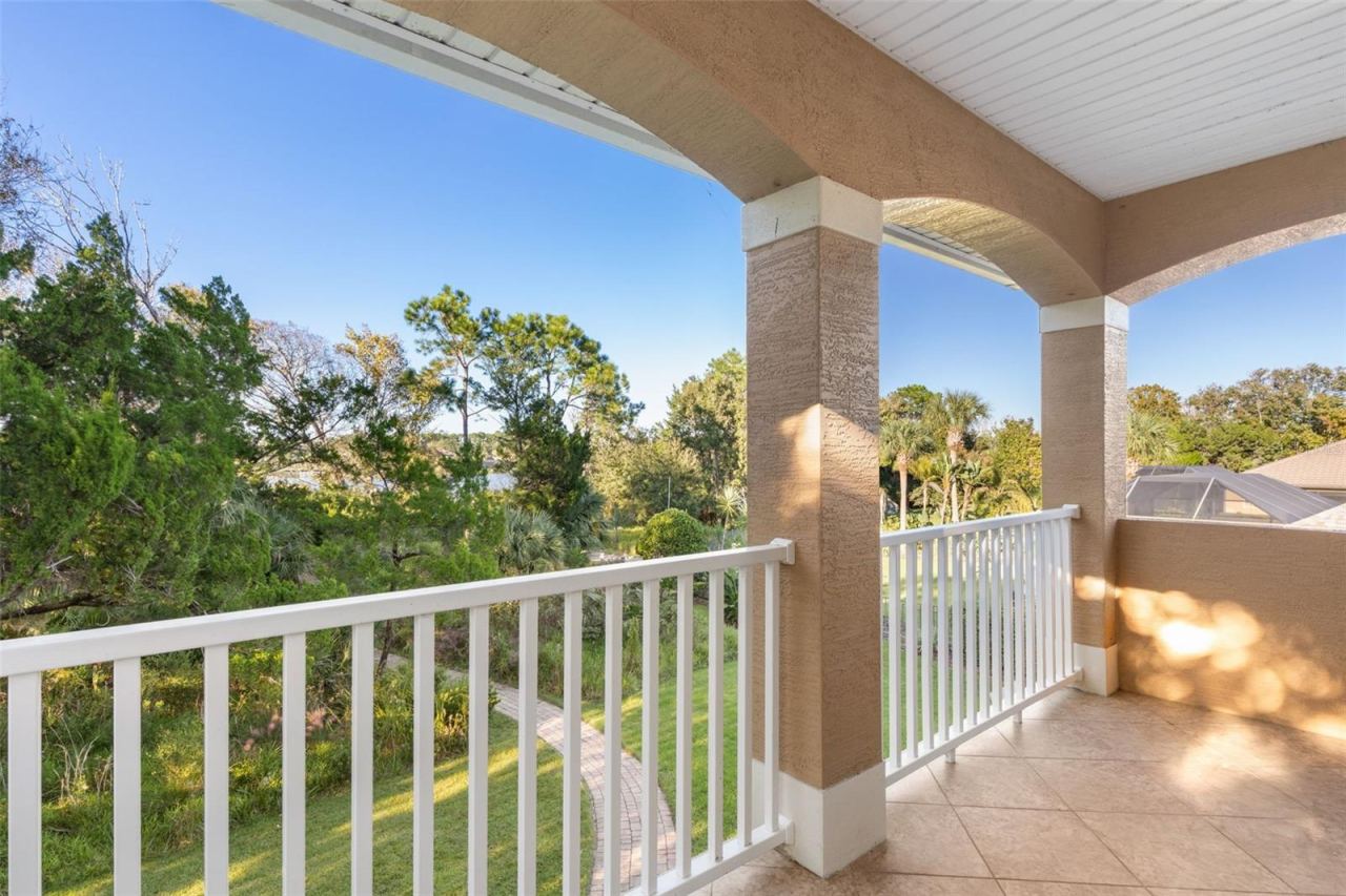 Photo 20 of 20: Step onto the private covered balcony and enjoy the peaceful natural surroundings, with glimpses of Emerald Lake through the trees.